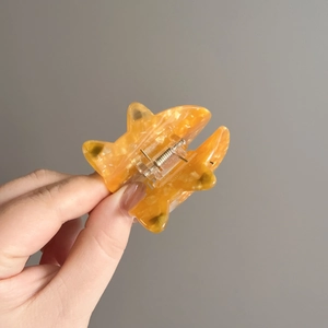 Handheld acetate hair claw clip in amber orange cat shape with durable metal spring