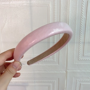 Détail d'un serre-tête rose rembourré en similicuir PU avec fini brillant et doublure
