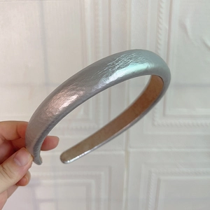Détail du serre-tête argenté rembourré avec texture plissée et doublure en velours