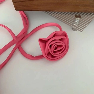 Detail view of handmade rose fabric choker with flexible strap on a display