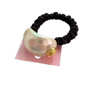 Elastic black hair scrunchie with a large pearl charm and gold accent on display card