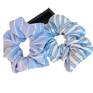 Set of two blue and white striped fabric scrunchies for hair styling in minimalist style