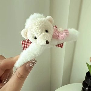 Détail de la pince à cheveux ours en peluche avec fourrure blanche et un nœud à carreaux