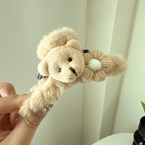 Détail de la pince à cheveux en peluche ours avec nœud à carreaux et fleur