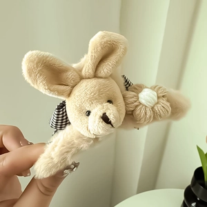 Détail de la pince à cheveux en peluche lapin avec nœud à carreaux et fausse fourrure