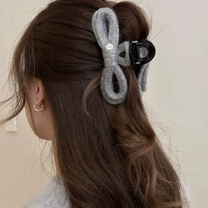 Elegant grey knitted bow hair claw clip for women, shown on hair with soft texture