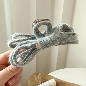 Handheld grey knitted bow hair claw clip with golden metal button for women's hairstyling