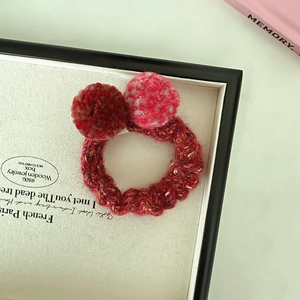 Vue macro détaillée d'un chouchou en maille douce avec des pompons en peluche contrastés