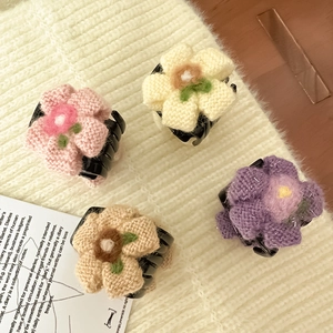 Primo piano dettagliato che mostra quattro mollette per capelli a fiore lavorate a mano