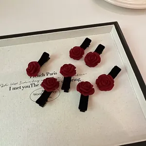 Élégant lot de 7 barrettes fleurs de camélia en velours bordeaux sur un plateau