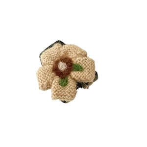 Pinza per capelli a fiore in maglia fatta a mano con petali beige e foglie verdi su bianco