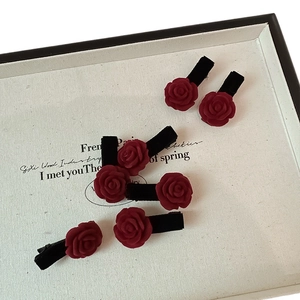 Lot de six pinces à cheveux fleurs de camélia floquées bordeaux sur présentoir blanc