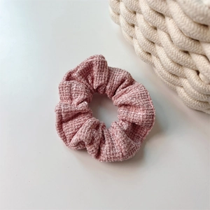 Dettaglio ravvicinato di elastico in tweed rosa con fibre glitterate e trama tessuta