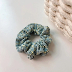 Primo piano dell'elastico in tweed blu con filo d'oro giallo e trama in tessuto ricca