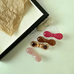 Vue détaillée de cinq élégantes barrettes à nœud en acétate aux couleurs minimalistes