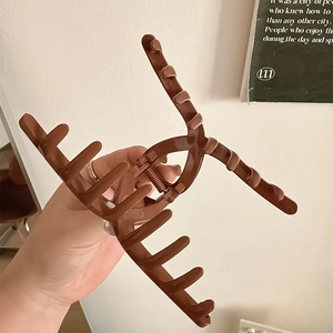 Elegante pinza per capelli grande color marrone caramello tenuta da una modella