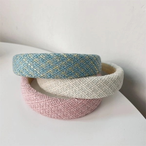 Primo piano di tre cerchietti imbottiti in tweed blu, bianco e rosa testurizzato