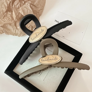 Large matte hair claw clips in black and khaki with oval handmade metal detail