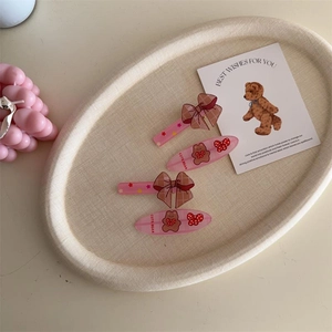 Detailed view of four cute plaid bow hair clips with brown bears and red cherries set