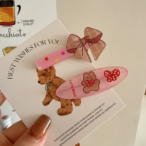 Set of cute pink plaid bow hair clips featuring a cartoon bear design and stars pattern