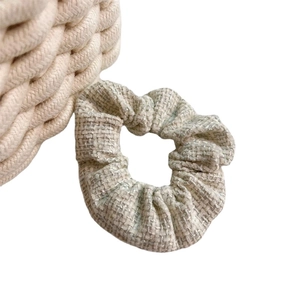 Elegante elastico in tweed beige con trama intrecciata e un'estetica morbida e minimalista