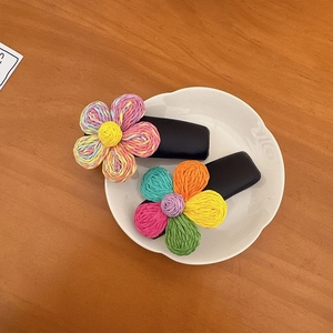 Fermagli per capelli a fiore intrecciati a mano con petali colorati su base nera