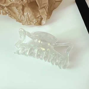 Macro shot of large acetate shark hair claw clip in iridescent pearly white finish