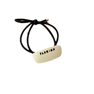 Elastico per capelli nero minimalista con placca in metallo dorato incisa FASHION