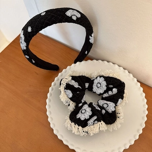 Détail du serre-tête en tweed et chouchou avec broderie florale et bords frangés