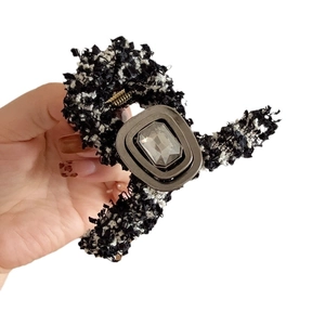 Elegant tweed hair claw clip with crystal embellishment in hand-held display