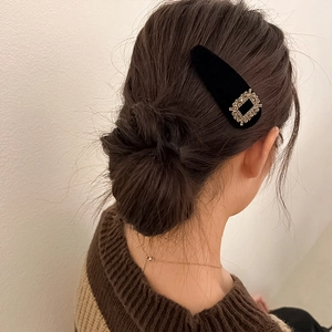 Vintage black velvet hair clip with a square rhinestone buckle worn on the side hair
