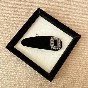 Detailed view of vintage black velvet hair clip featuring sparkling rhinestone buckle