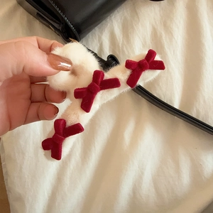 Pinza per capelli invernale in peluche con fiocchi di velluto bordeaux tenuta in mano