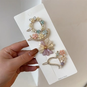 Détail d'un lot de 4 barrettes à cheveux avec perles, cristaux et marguerites colorées