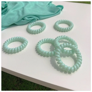 Lot de 5 élastiques à cheveux spirales vert menthe sur une surface blanche unie