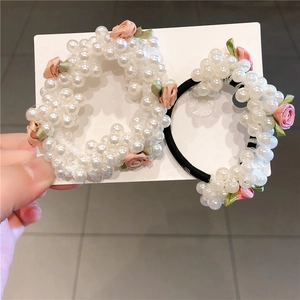 Vue détaillée des chouchous perles avec roses en tissu et cordon élastique noir