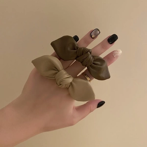 Elegant leather bow hair ties in olive green and beige colors for ponytails