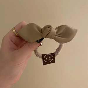 Elegant leather bow hair tie in beige for high ponytail hairstyles and hair styling