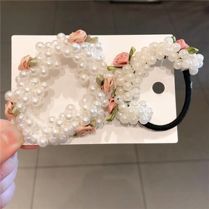 Ensemble de deux chouchous en perles avec roses en tissu rose sur carte blanche