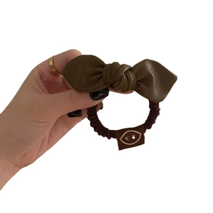 Deep brown faux leather bow scrunchie with wink label and pleated elastic hair tie