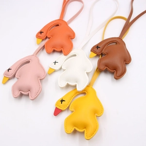 Handmade leather swan bag charms in five colors with cross-stitched eyes and long lanyards