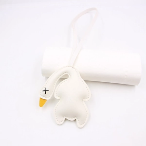 Detailed view of a white PU leather swan bag charm with yellow beak and long lanyard strap