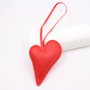 Red heart-shaped leather charm with matching stitching and long lanyard for bags