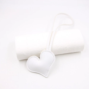 Macro detail of white heart leather pendant with handmade stitching and slim lanyard