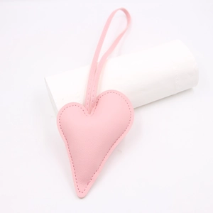 Close-up of pink heart-shaped leather pendant with neat edge stitching and long cord