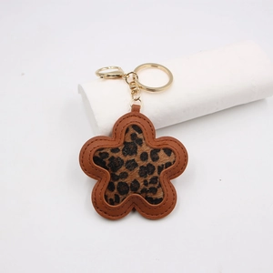 Leopard print flower keychain with brown leather edges and gold metal hardware for bags