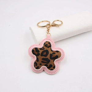 Detail of flower keychain featuring pink faux leather, leopard print fabric and gold hook