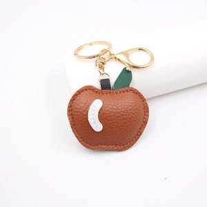 Detailed close-up of brown PU leather apple keychain with golden lobster clasp and metal ring