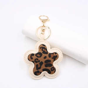Close-up of leopard print flower keychain with gold metal clasp and leather stitching