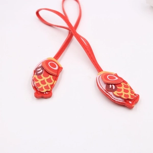 Detail of red carp leather charms with traditional fish pattern and fine stitching details